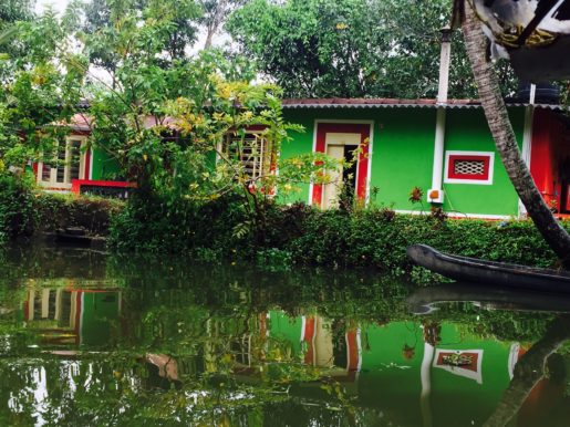 Brightly coloured house and reflections on Kerala backwaters