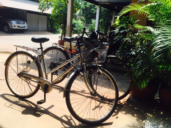 Two push bikes outside a Khmer wooden house on stilts when living and working in Siem Reap Cambodia