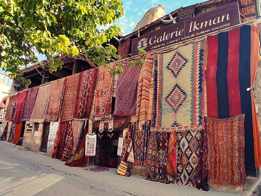 Lots of colourful rugs displayed outside carpet shop in Goreme, Cappadocia