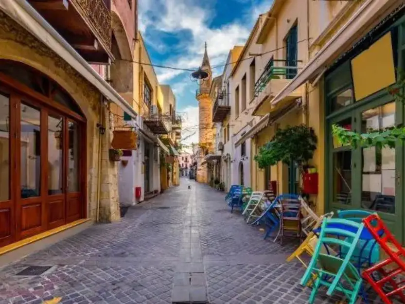 Street in Chania Old Town with colourful chairs stacked n the right foreground