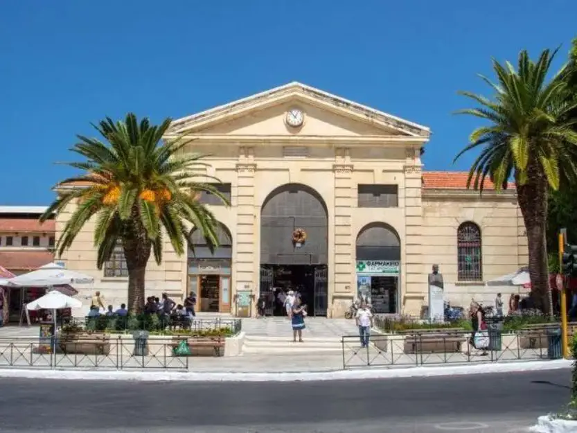 Agora Central Market in Chania, a sandstone coloured building with a palm tree each side.