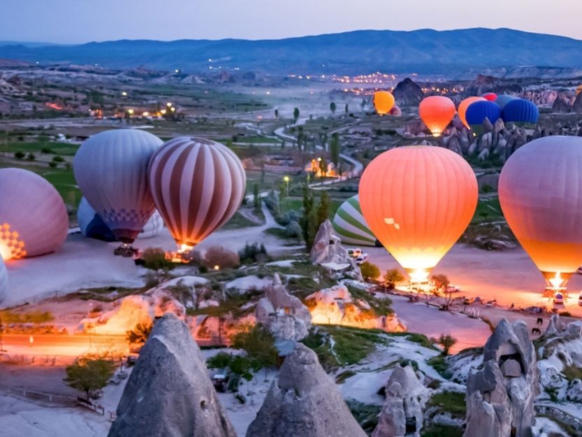 Hot air balloons all lit up at launch site in Cappadocia