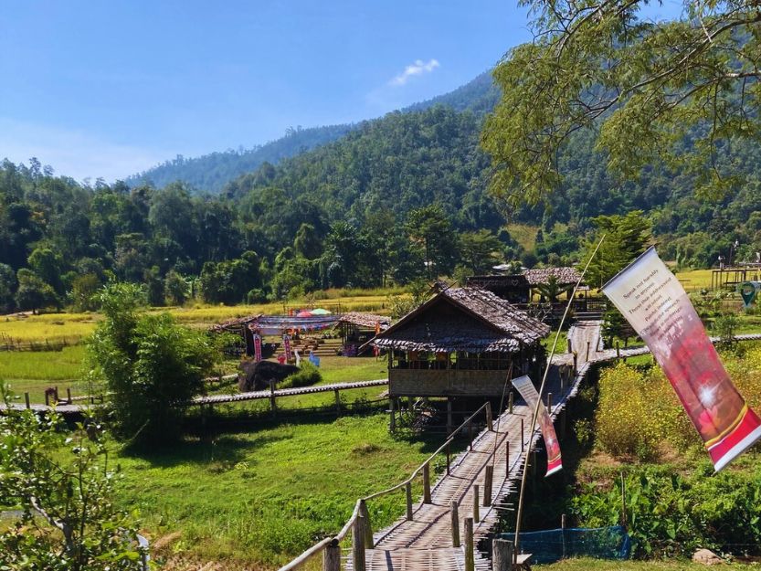 Kho Ku So Bamboo Bridge in Pai, Thailand. It passes over green paddy fields to Wat Pa Huai Khai Khiri Temple