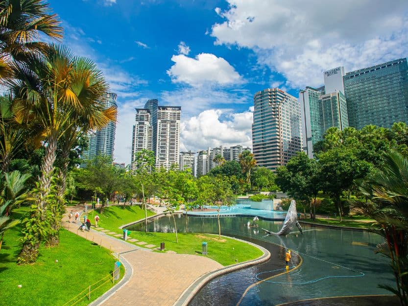 KLCC Park in Kuala Lumpur KLCC Park in Kuala Lumpur with green grass and palm trees on the left and lake on the right.