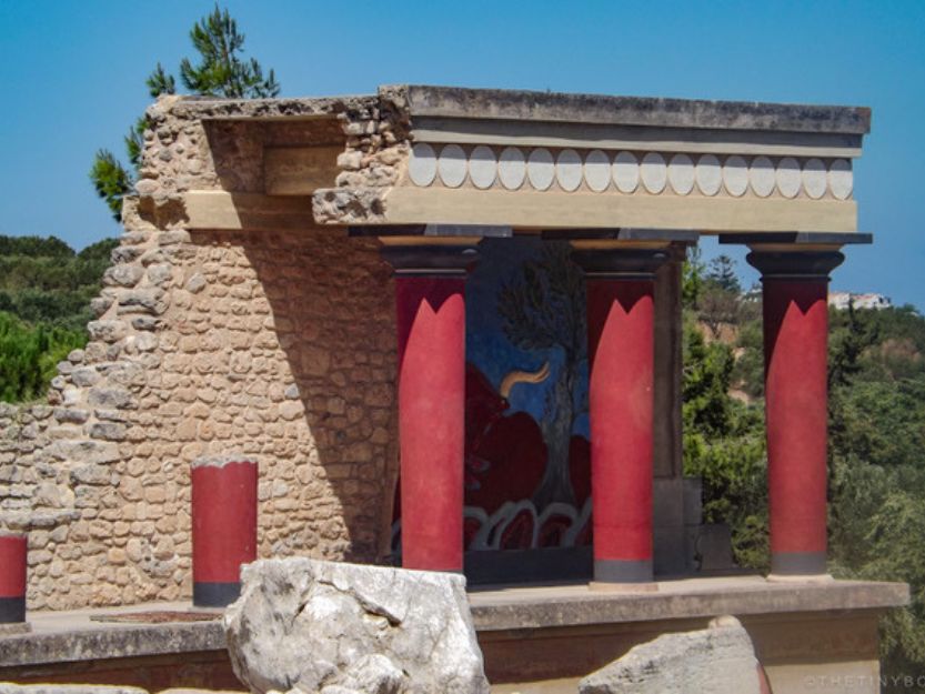 Knossos in Heraklion on Crete Island - beige stone temple with red columns