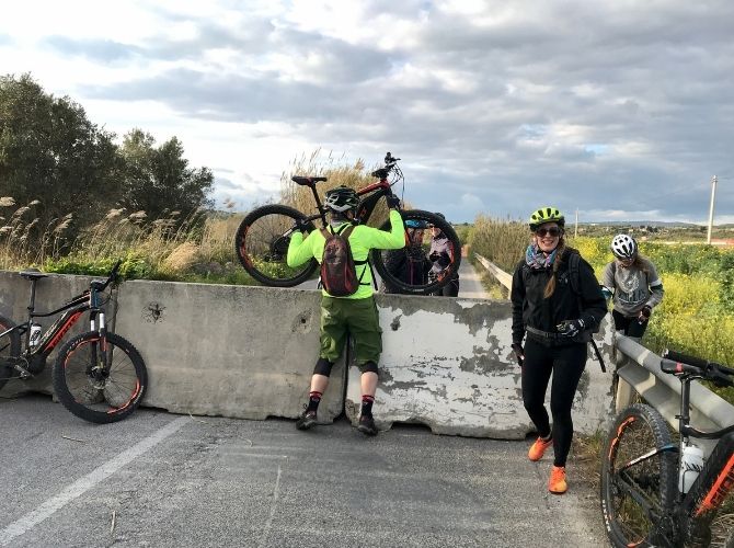 Lifting bikes over a blockade in Sicily.