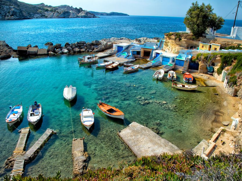 Mandrakia Bay in Milos, Fishing boats in a little bay with rocky shore on the left