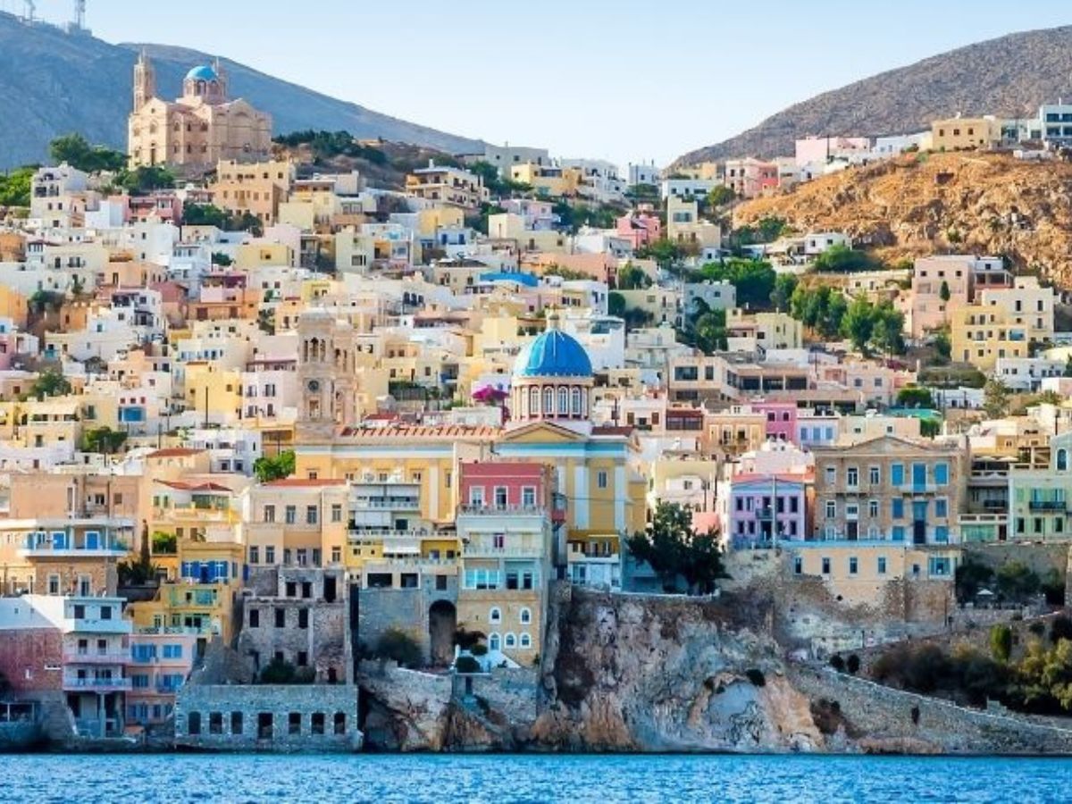Most beautiful Greek islands - colourful houses on a hillside overlooking the blue sea