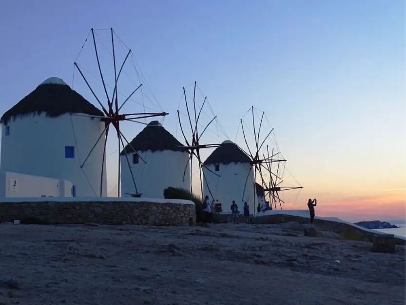 Three white windmills at sunset on Mykonos Island in Greece 