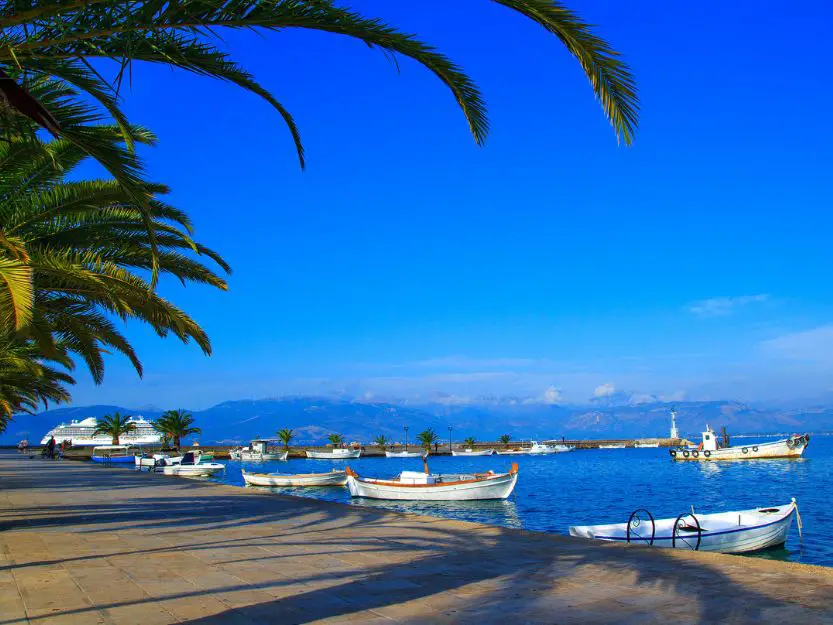Nafplio port lined with palm trees with boats on the water