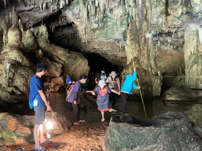 People getting off a narrow bamboo raft in Nam Lod Cave in Pai, Thailand