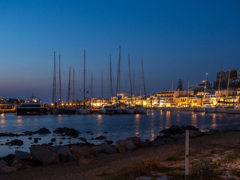 A bay full of yachts on Naxos Island in Greece at night.