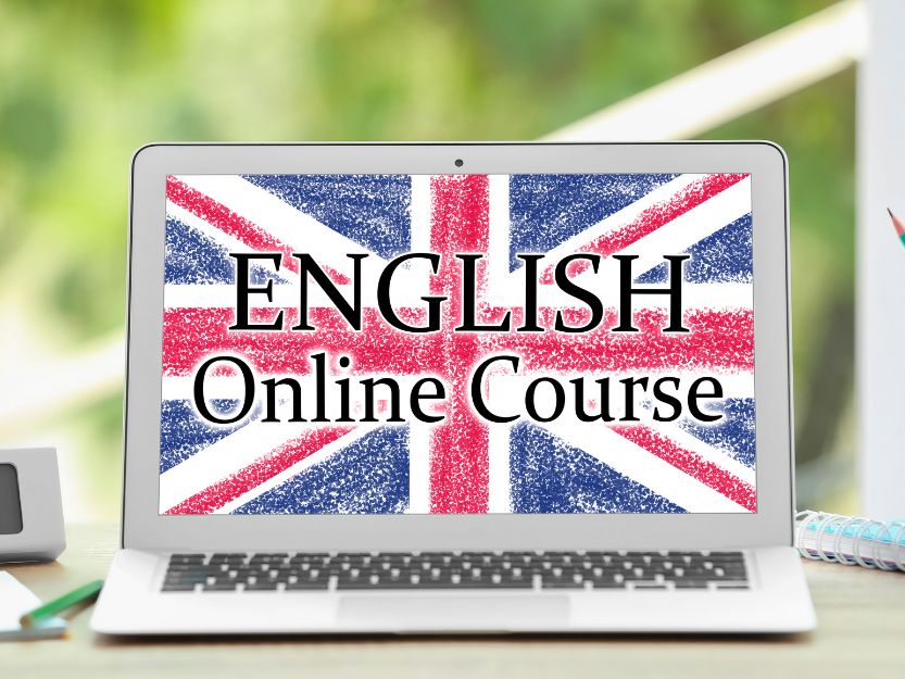 Online English Teaching, Image of a silver laptop screen with the red, white and blue Union Jack Flag with a blurred green background.