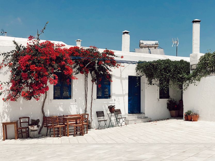 Paros, an Aegean Island in Greece. White house with blue shutters and red bouganvillea
