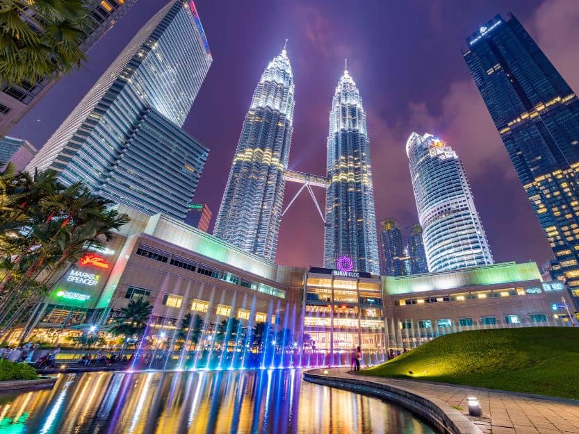 Petronas Towers in Kuala Lumpur Petronas Towers in Kuala Lumpur at night all lit up with coloured fountains in front.