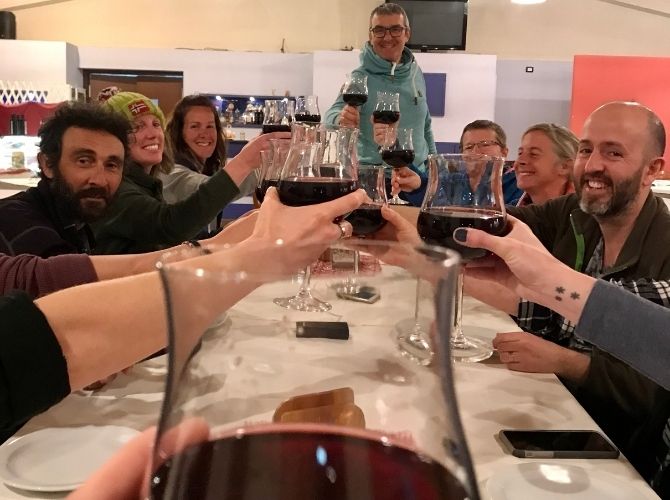 Group making a toast with red wine at the restaurant in Agritourismo Giannavi in Sicily