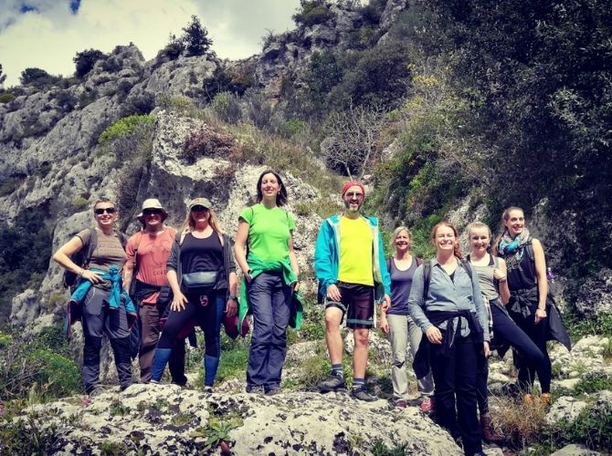 Small tour group standing on rocks in Pantalica, Anapo Valley in Sicily.