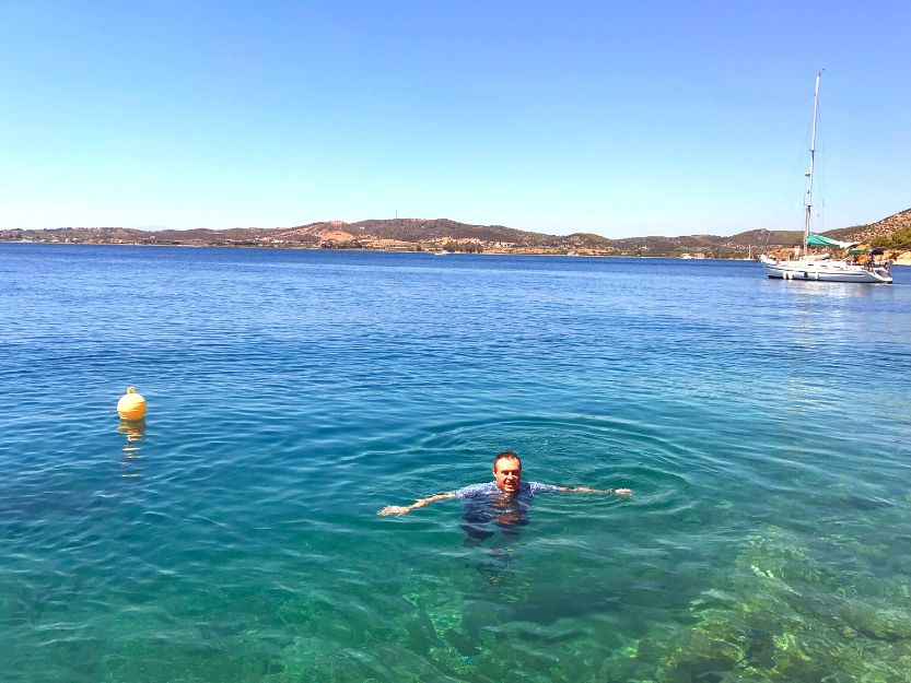 Andrew swimming in the crystal blue sea on Mandrakia side of Ermioni in Greece. He is wearing a light blue shirt so he doesn't get sunburnt