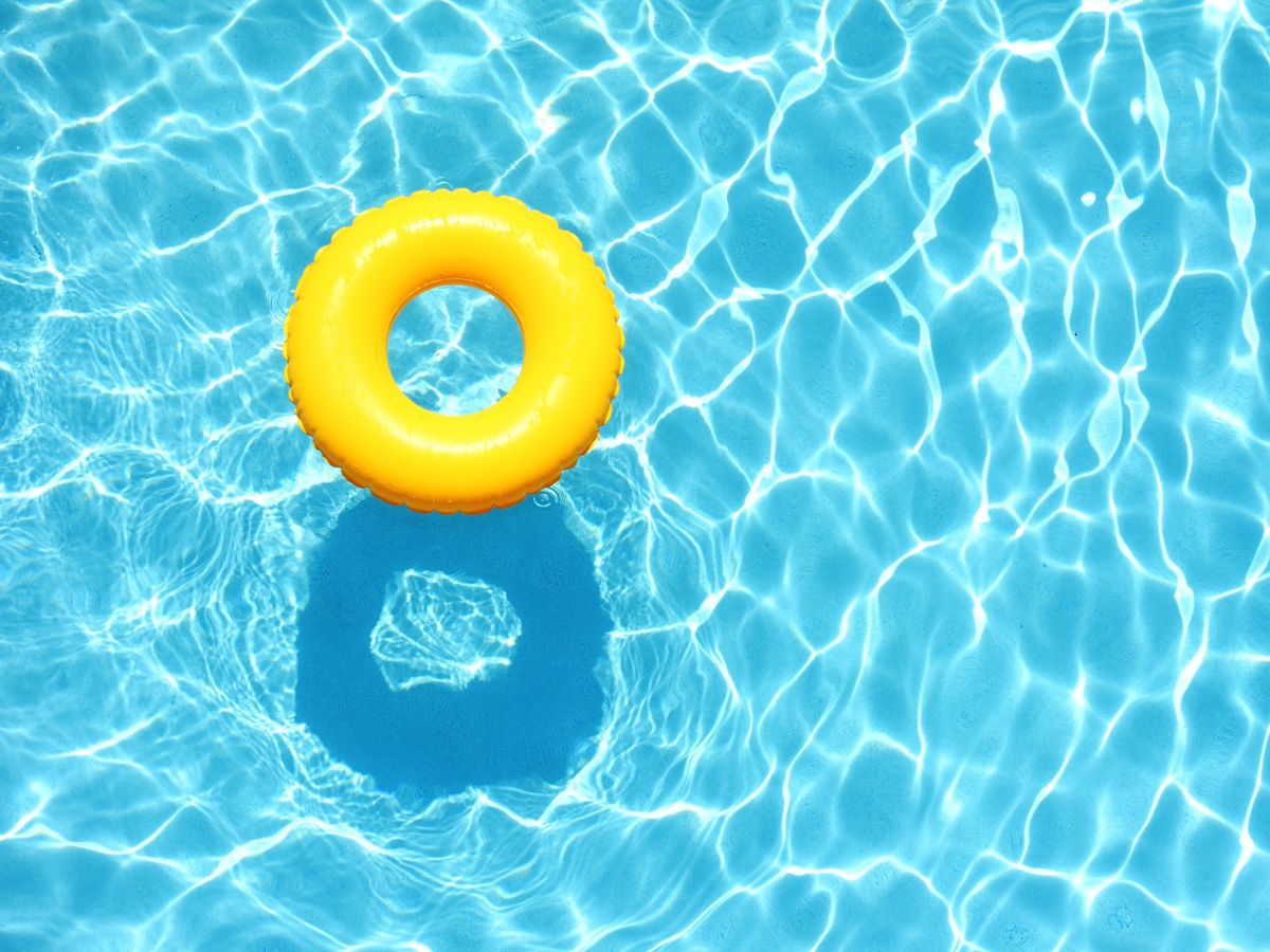 Swimming Pools in Siem Reap in Cambodia. Yellow rubber ring floating in the surface of sparkling turquoise swimming pool water.