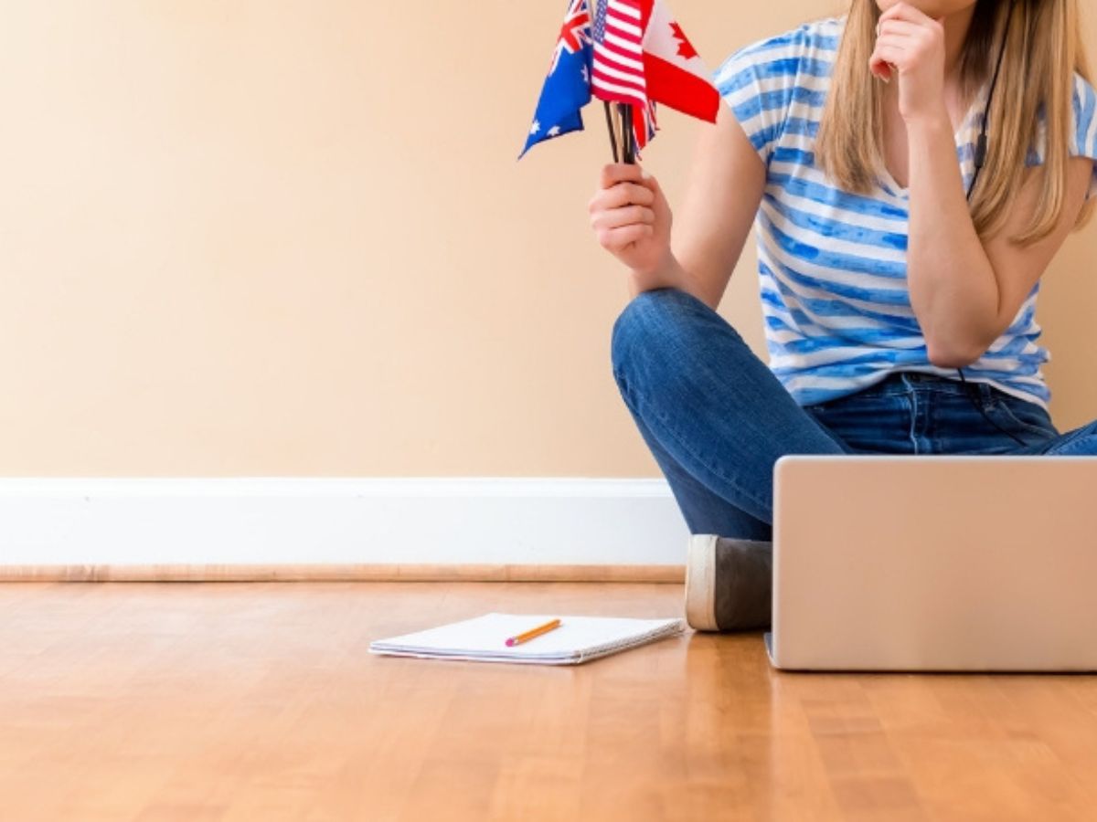 Teach English Online - teacher sitting cross legged on floor in front of laptop teacheing English