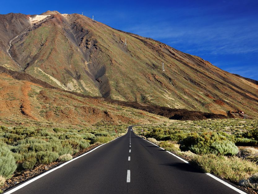 Teide National Park, Tenerife. Imag of road leading to Mount Teide with blue sky in background.