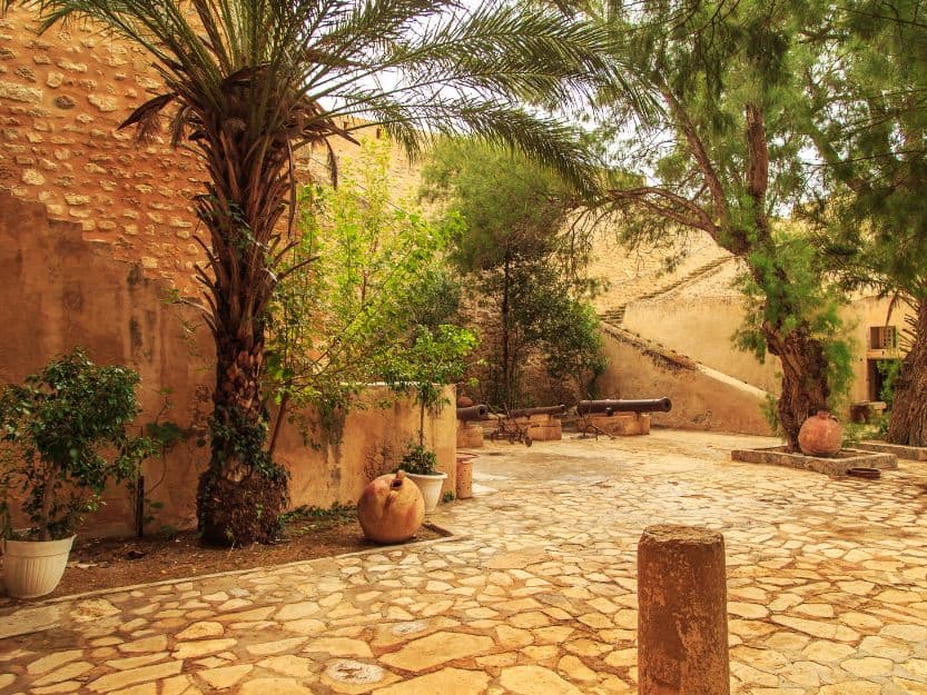 Palm tree filled stone courtyard in the Kasbah in Hammamet