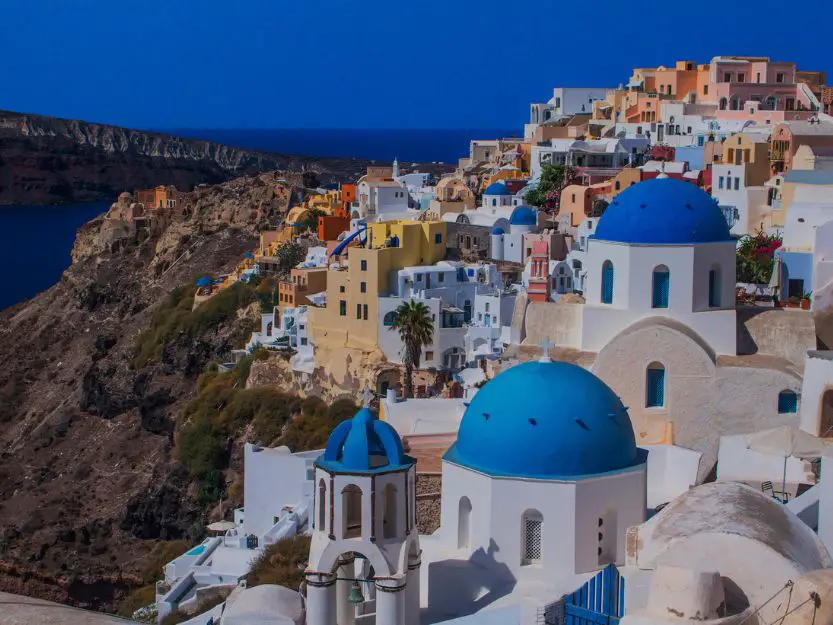 White and colourful houses, with white churches with blue domes on Santorini Island in Greece