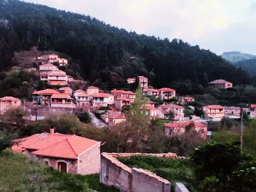 Tsintzina Village at dusk. Red tile roofed houses surrounded by fir covered mountain slopes