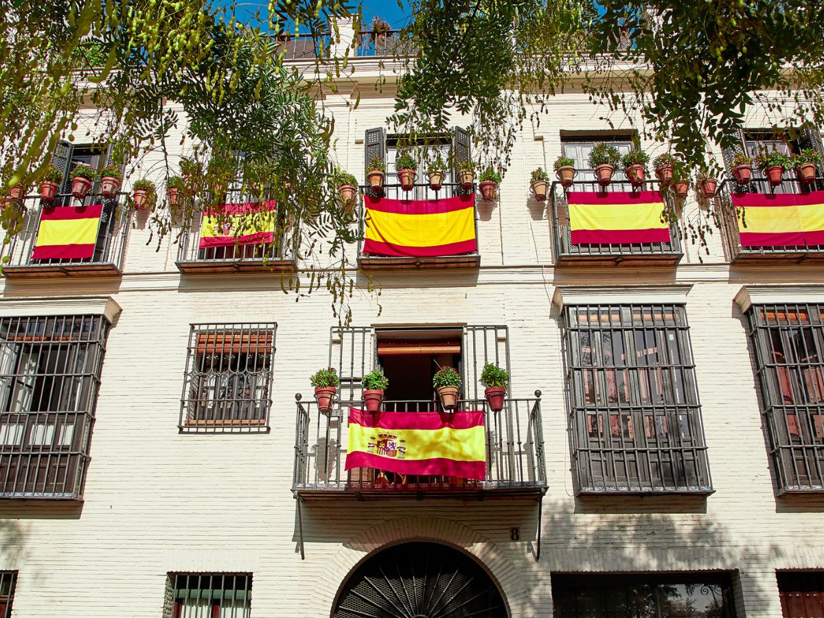 Pros and cons of living in Spain. Spanish flags hanging on apartment balconies